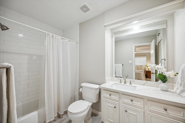 full bathroom featuring hardwood / wood-style floors, vanity, toilet, a textured ceiling, and shower / tub combo