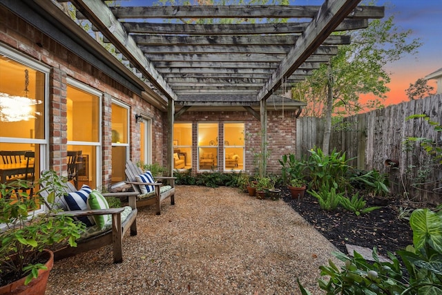 patio terrace at dusk featuring a pergola