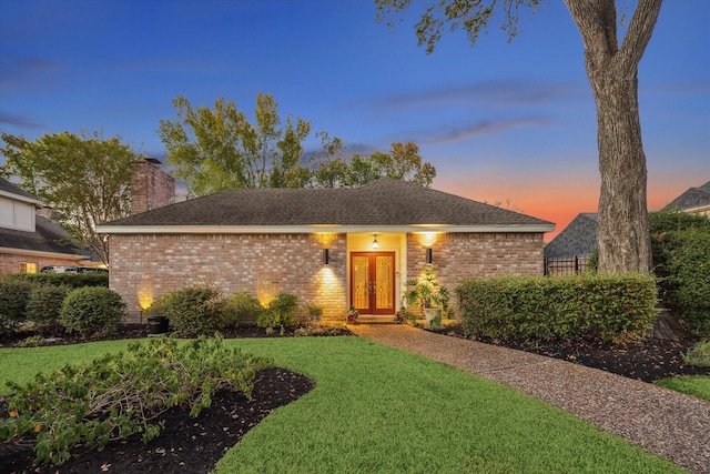 ranch-style home featuring french doors and a lawn