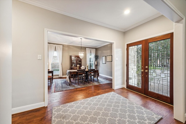 entryway featuring a notable chandelier, dark hardwood / wood-style floors, ornamental molding, and french doors