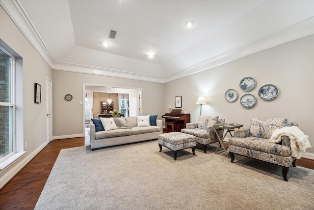 living room featuring dark hardwood / wood-style floors, a raised ceiling, and crown molding