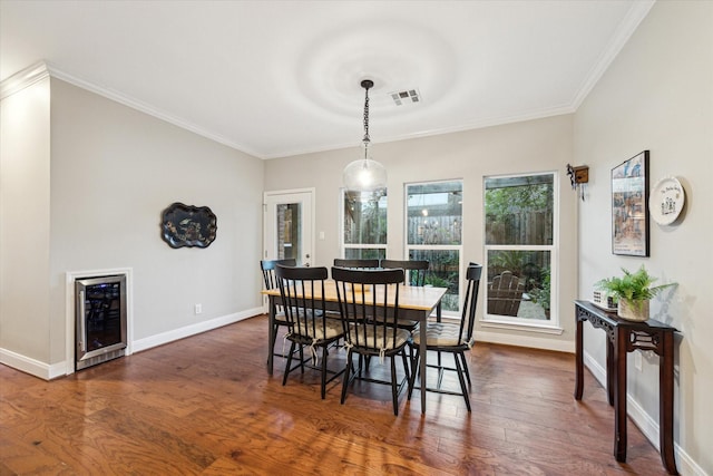 dining room with wine cooler, crown molding, and dark hardwood / wood-style floors