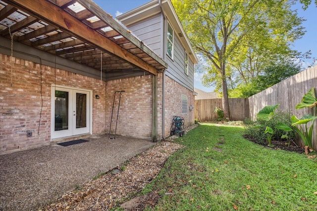 exterior space featuring french doors, a patio area, and a lawn