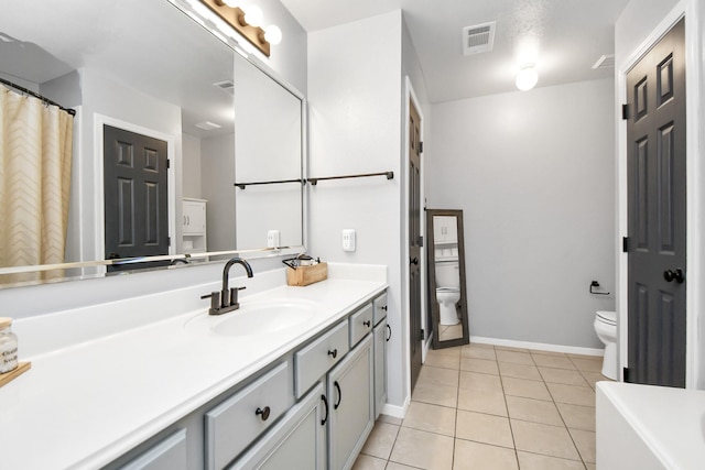 bathroom with tile patterned flooring, vanity, and toilet