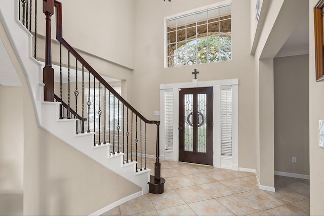 tiled entryway with french doors and a high ceiling