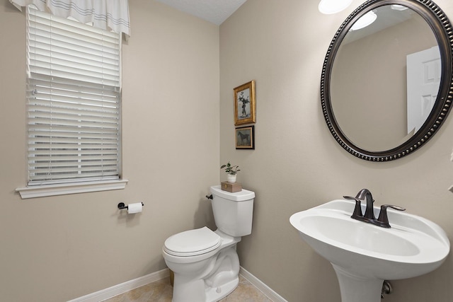 bathroom with tile patterned flooring, toilet, and sink