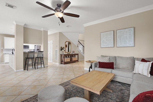 tiled living room featuring ceiling fan and crown molding