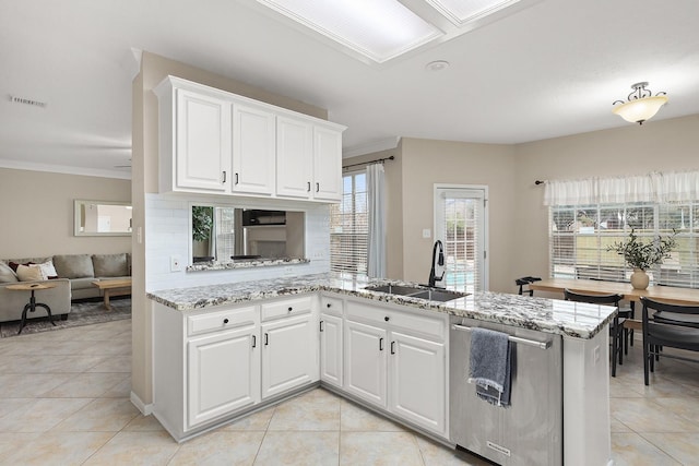 kitchen with kitchen peninsula, sink, stainless steel dishwasher, light tile patterned flooring, and white cabinetry