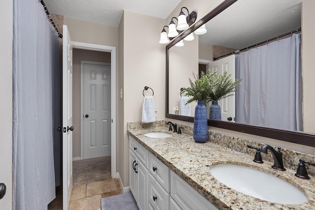 bathroom featuring a textured ceiling and vanity