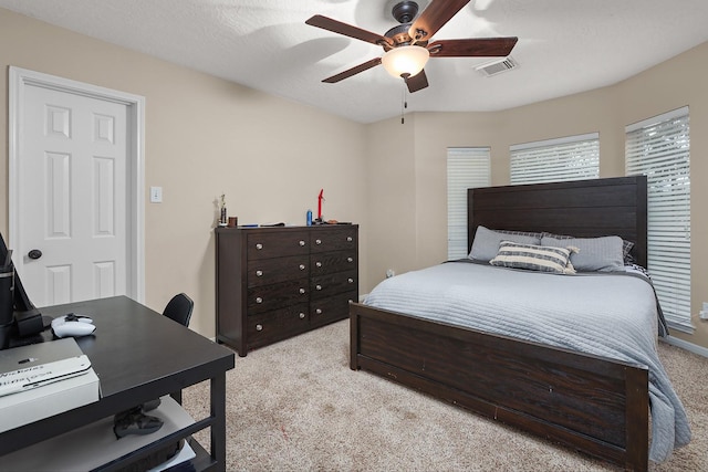 carpeted bedroom featuring ceiling fan and a textured ceiling