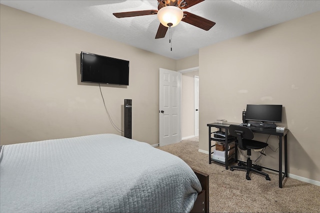 carpeted bedroom with ceiling fan and a textured ceiling