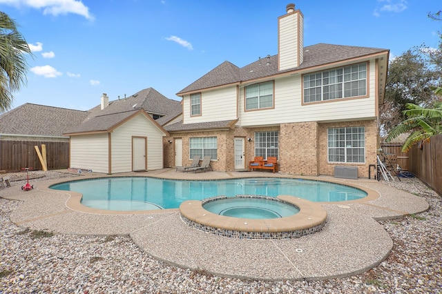 view of swimming pool with an in ground hot tub