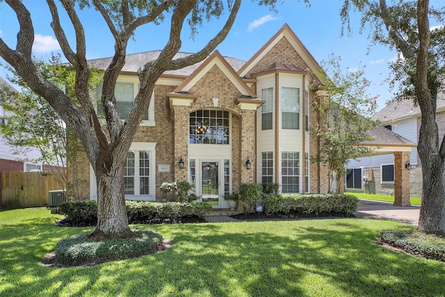 view of front of property with a front lawn and central AC