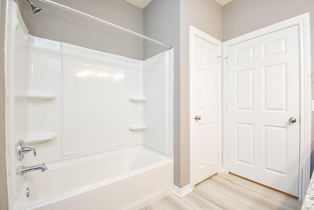 bathroom with bathing tub / shower combination and hardwood / wood-style flooring