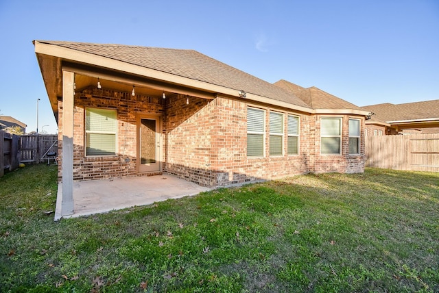 rear view of property featuring a yard and a patio