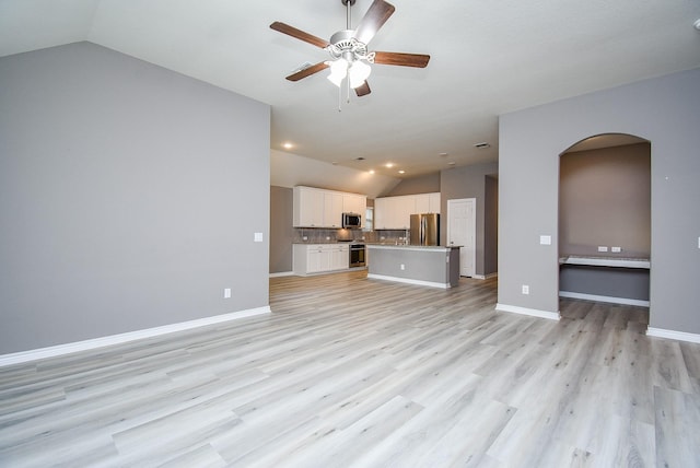 unfurnished living room featuring ceiling fan, light hardwood / wood-style floors, and lofted ceiling