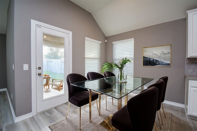 dining space featuring light hardwood / wood-style floors and vaulted ceiling