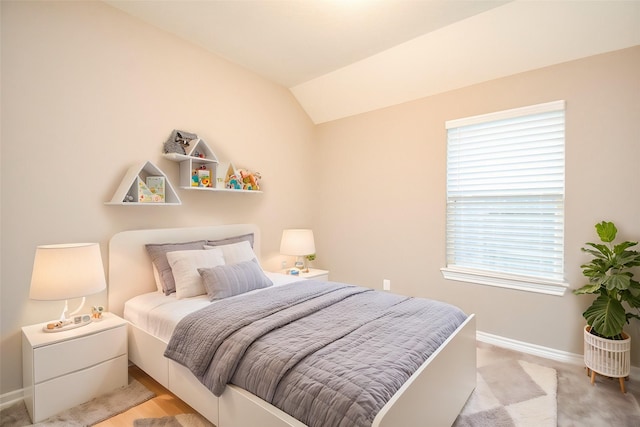 bedroom featuring lofted ceiling and multiple windows