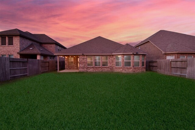 back house at dusk with a yard