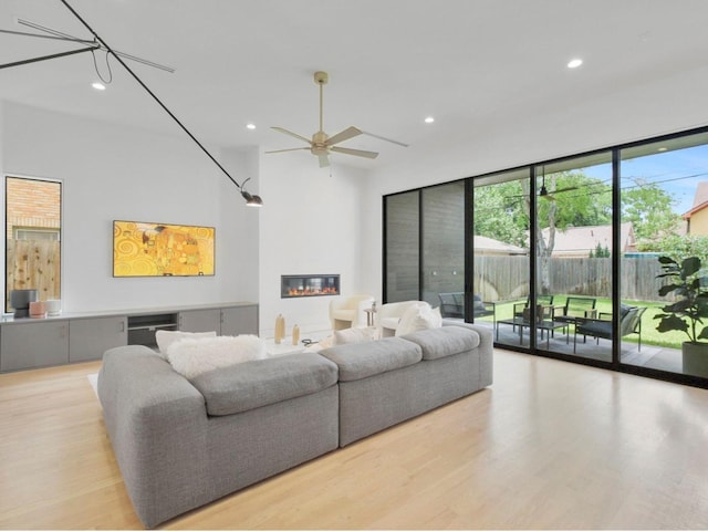 living room with wine cooler, ceiling fan, and light hardwood / wood-style flooring