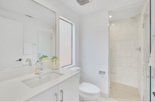 bathroom featuring a wealth of natural light, toilet, vanity, and walk in shower