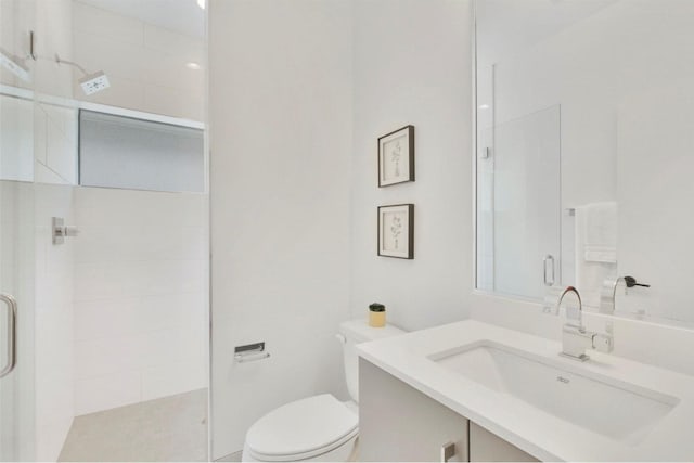 bathroom with an enclosed shower, vanity, and toilet