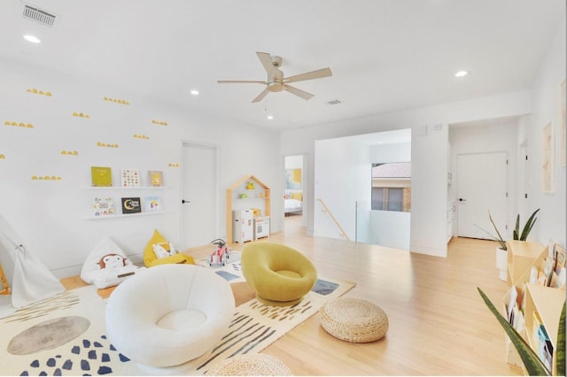 game room with ceiling fan and light wood-type flooring