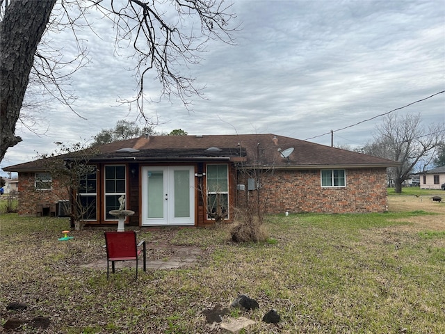 back of house featuring french doors and a lawn