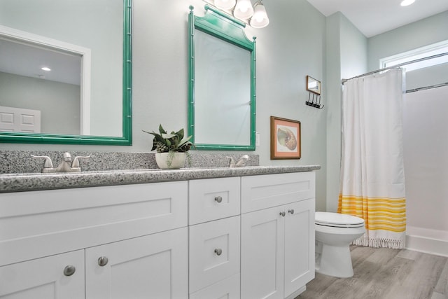 bathroom featuring a shower with shower curtain, vanity, hardwood / wood-style flooring, and toilet