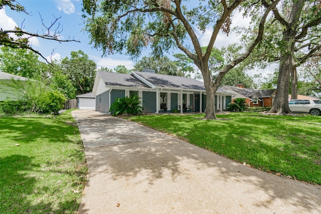 single story home featuring a garage, an outbuilding, and a front yard