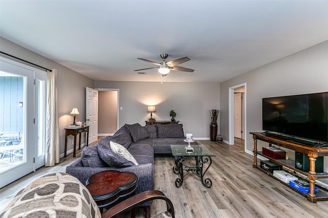 living room with light hardwood / wood-style flooring and ceiling fan