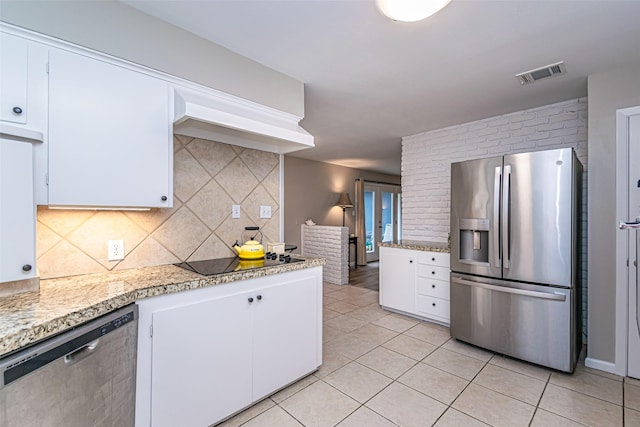 kitchen featuring white cabinets, appliances with stainless steel finishes, backsplash, and light tile patterned flooring