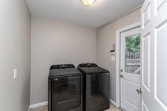 washroom featuring light tile patterned floors and washer and clothes dryer