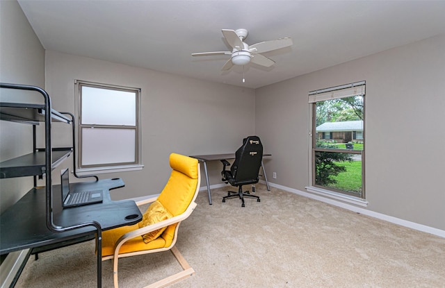 carpeted office space featuring ceiling fan