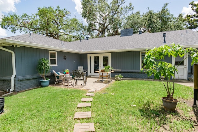 rear view of house featuring a yard and a patio