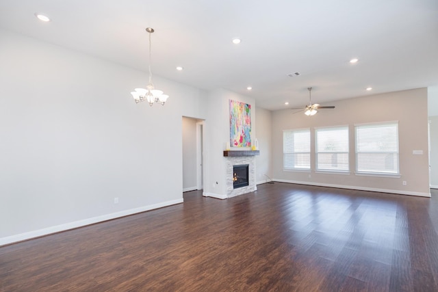 unfurnished living room featuring ceiling fan with notable chandelier and dark hardwood / wood-style flooring