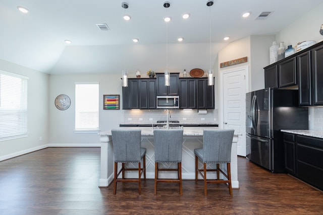 kitchen with vaulted ceiling, black fridge with ice dispenser, pendant lighting, and light stone counters