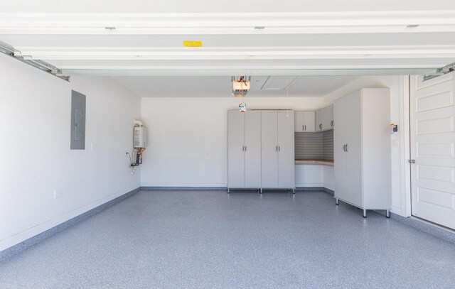 garage featuring water heater, a garage door opener, and electric panel