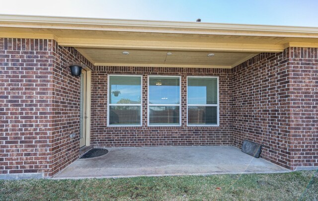 view of exterior entry with a patio area