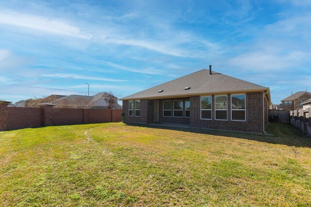 rear view of property with a lawn