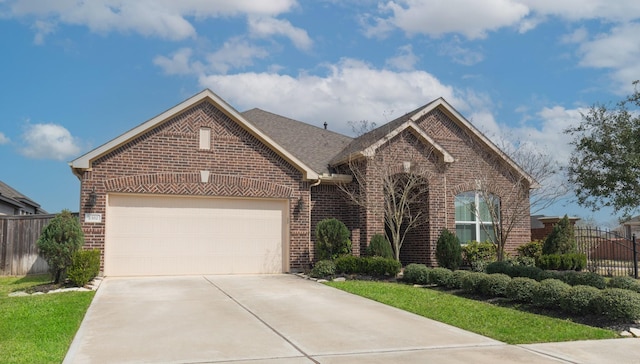 view of front of property featuring driveway, brick siding, an attached garage, and fence