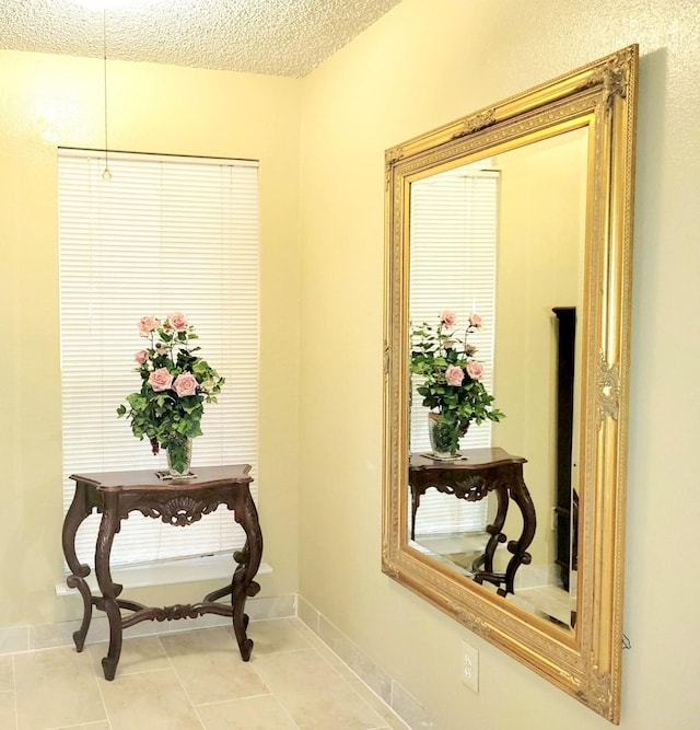 hall with light tile patterned floors and a textured ceiling