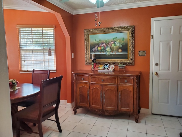 tiled dining area with ornamental molding and a textured ceiling