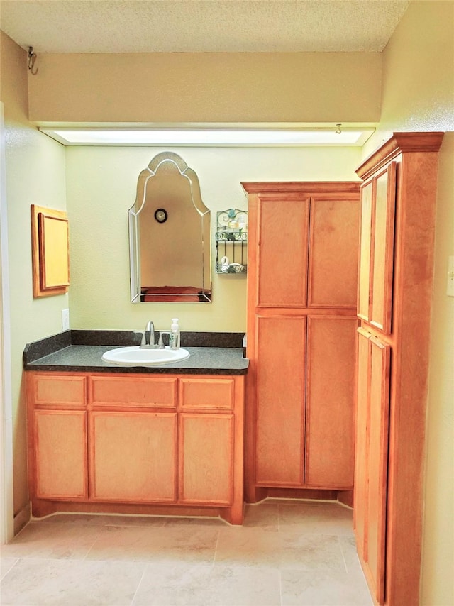 bathroom featuring a textured ceiling and vanity