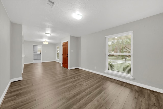 interior space featuring plenty of natural light, a textured ceiling, and hardwood / wood-style flooring