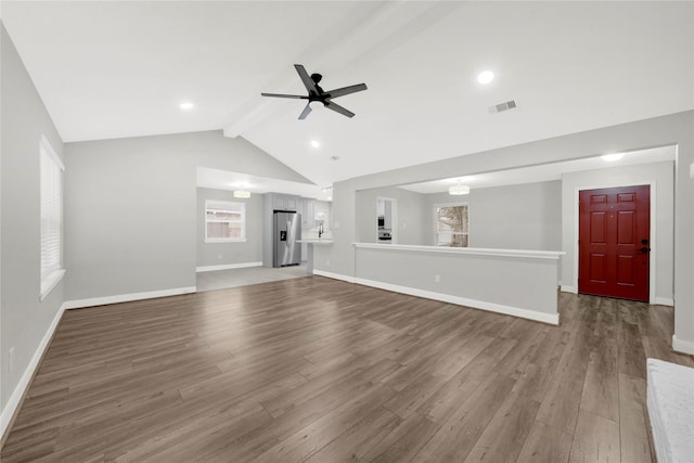 unfurnished living room with vaulted ceiling with beams, wood-type flooring, and ceiling fan with notable chandelier