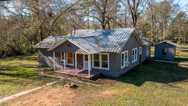 view of front of property featuring cooling unit, a shed, and a front yard