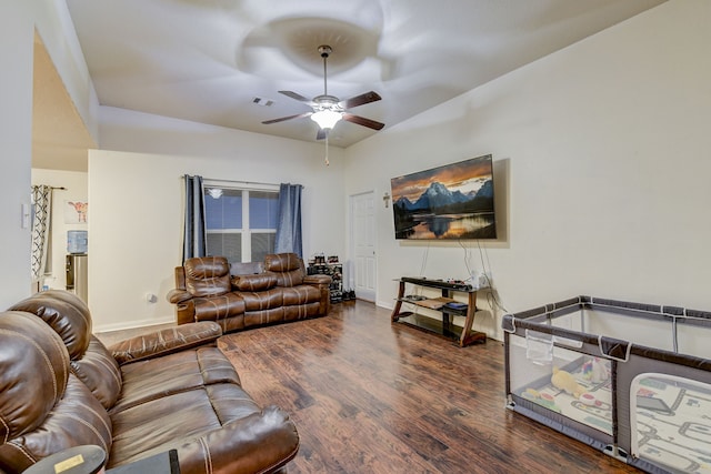 living room featuring ceiling fan and dark wood-type flooring