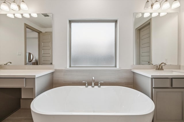 bathroom featuring hardwood / wood-style floors, vanity, and a bath