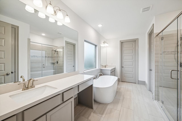 bathroom featuring vanity and independent shower and bath